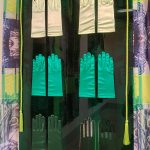 pairs of satin gloves on green plastic