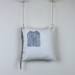 fringed pillow hanging on the wall