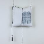fringed pillow hanging from the wall