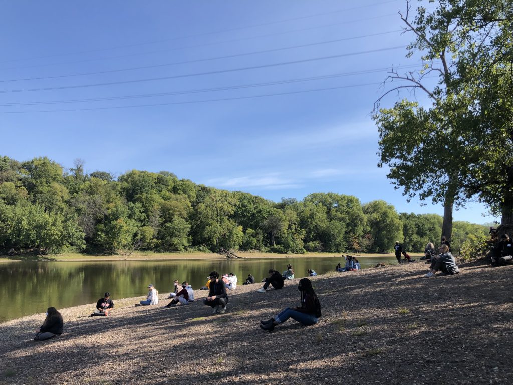 people sitting on shore of river