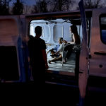 peole in a van at night viewing tv