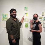 two people pointing at sold artwork