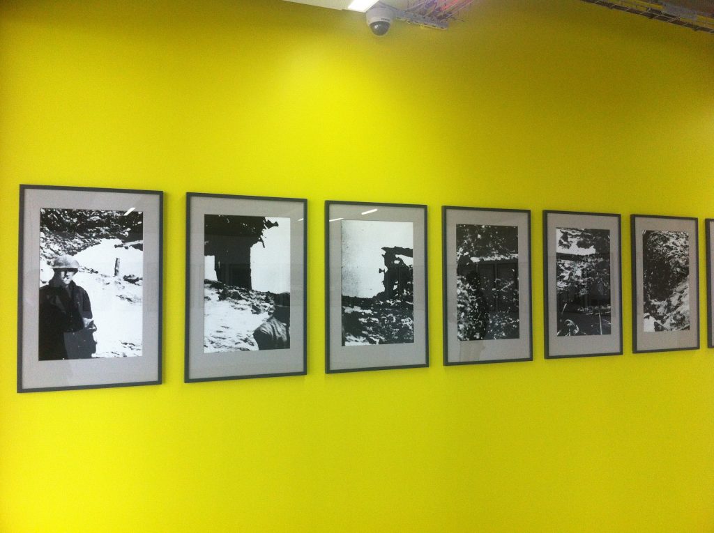 Black and white Outdoor photographs framed and hanging on a yellow wall