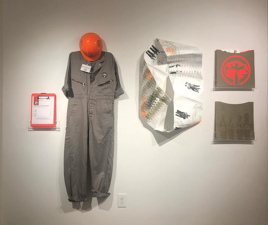 a suit and clipboard and some printed materials hanging on a wall